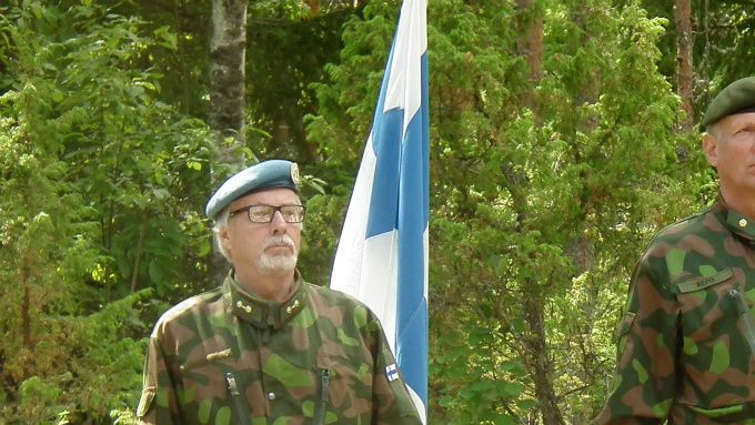 Suomen lippu tuotiin maanpuolustusjuhlaan Sarsuinmäen tykkipattereille su 5.7.2015 liki 300 päisen yleisön keskelle reservin ylil Markku Vihavaisen, res majuri Esa Revon ja res kapteeni Olli Uotisen toimesta.